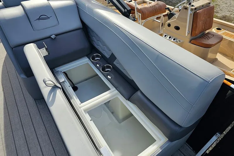 Slide: The Image of 2026 SunCatcher Fusion 324SS boat interior with storage compartment and cup holders. - 20