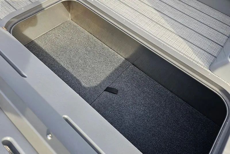 Slide: The Image of 2026 SunCatcher Fusion 324SS storage compartment with carpeted interior and sleek design. - 30