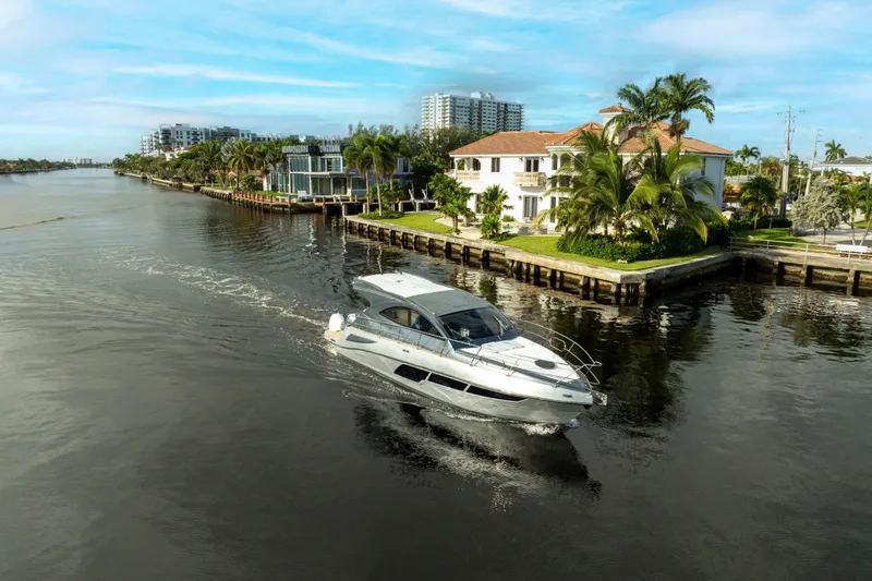 Slide: The Image of Luxury Valiatt 410HT yacht cruising near waterfront homes, 2025 model. - 3