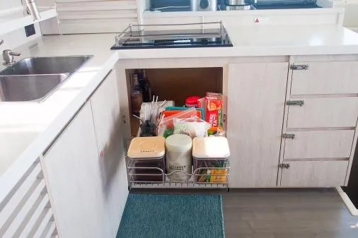 Slide: The Image of Modern kitchen storage in a 2015 Leopard 48 yacht, featuring organized pantry items. - 10