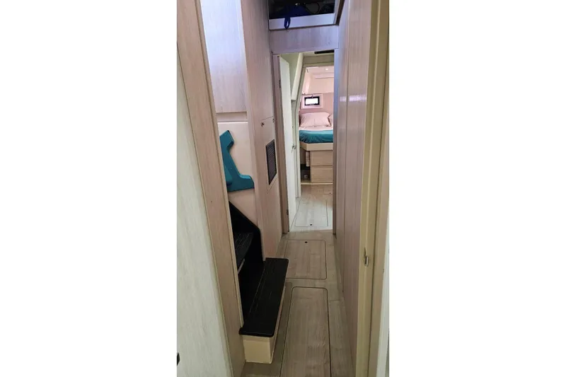 Slide: The Image of Interior hallway of 2015 Leopard 48 yacht, featuring wooden flooring and cozy cabin view. - 32