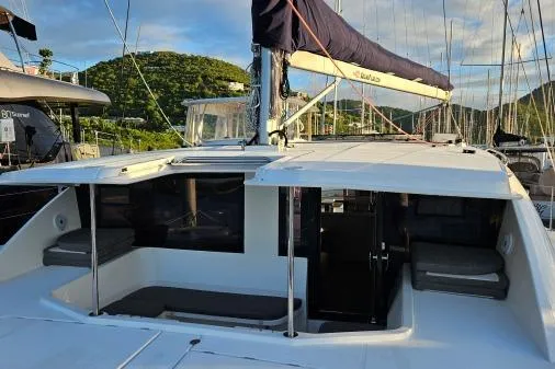 Slide: The Image of 2015 Leopard 48 catamaran with spacious deck, docked in a scenic marina. - 50
