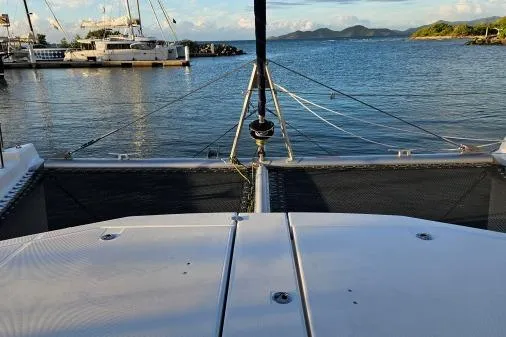 Slide: The Image of 2015 Leopard 48 catamaran docked in a serene marina with distant islands. - 59