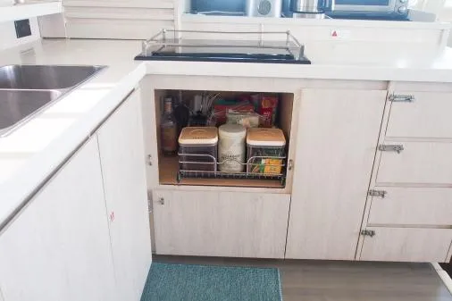 Slide: The Image of Modern kitchen storage in a 2015 Leopard 48 yacht, featuring organized pantry shelves. - 7