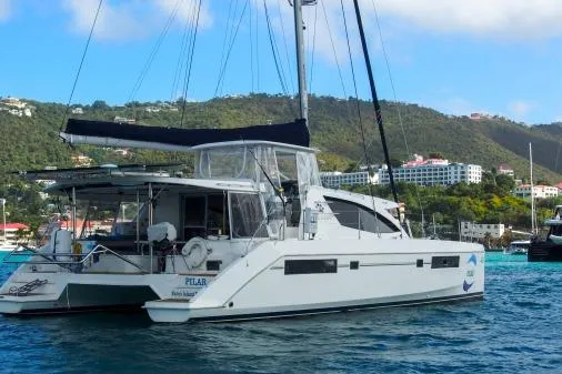 Slide: The Image of 2015 Leopard 48 catamaran sailing in scenic coastal waters with lush hills in the background. - 73