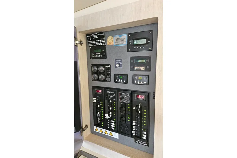 Slide: The Image of Electrical control panel of a 2015 Leopard 48 yacht with various switches and displays. - 77