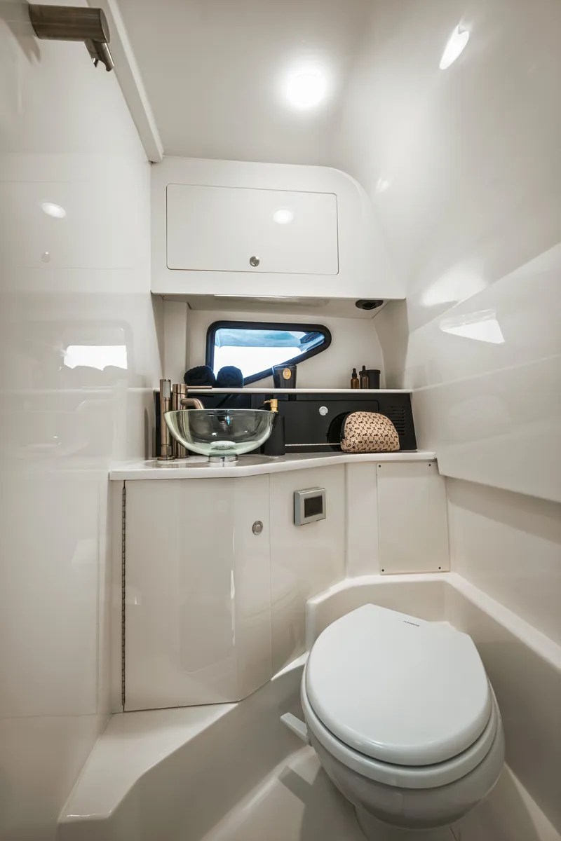 Slide: The Image of The image shows a modern boat bathroom with a toilet and a sink. - 24