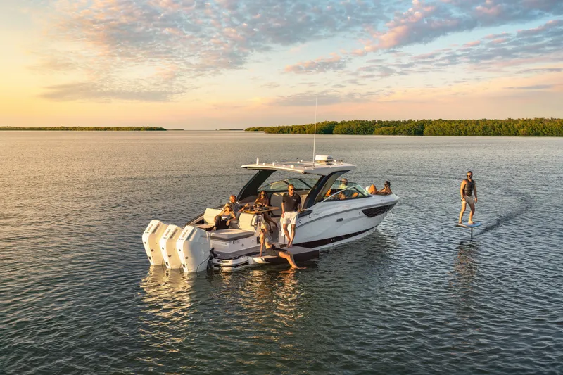 Slide: The Image of A 2026 Sea Ray SLX 360 Outboard on calm water at sunset, with several people on board. - 3