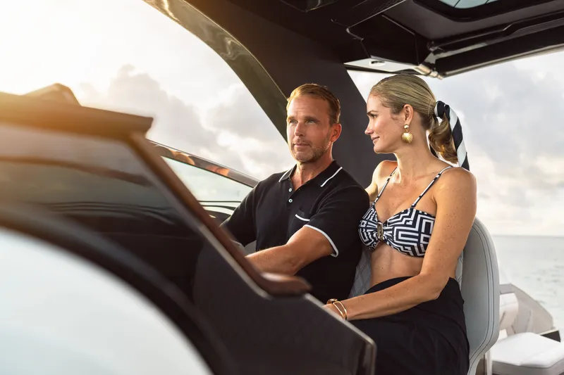 Slide: The Image of A couple sits relaxed in the cockpit of a Sea Ray SLX 360 Outboard, surrounded by sunlight. - 9