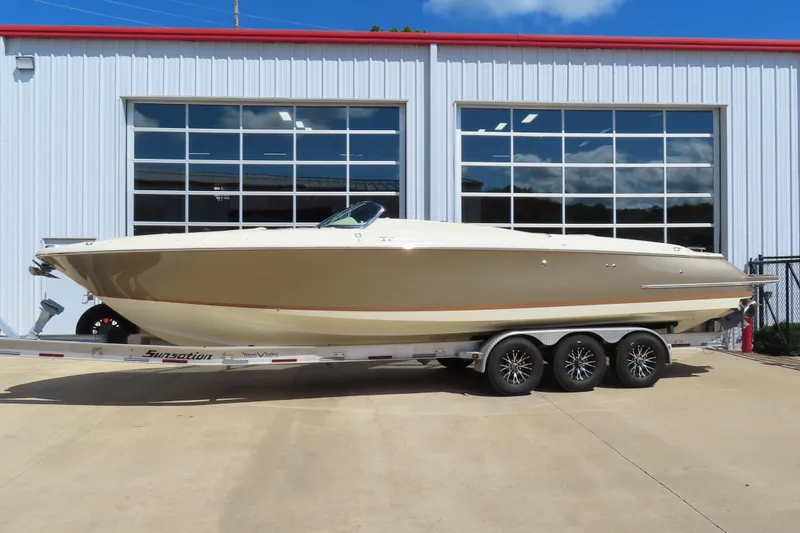 The Image of 2018 Chris Craft Launch 34 boat on trailer outside a modern garage. - 0