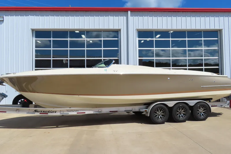 Slide: The Image of 2018 Chris Craft Launch 34 boat on trailer outside a garage. - 1