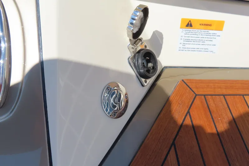 Slide: The Image of 2018 Chris Craft Launch 34 boat detail with power outlet and warning label. - 11