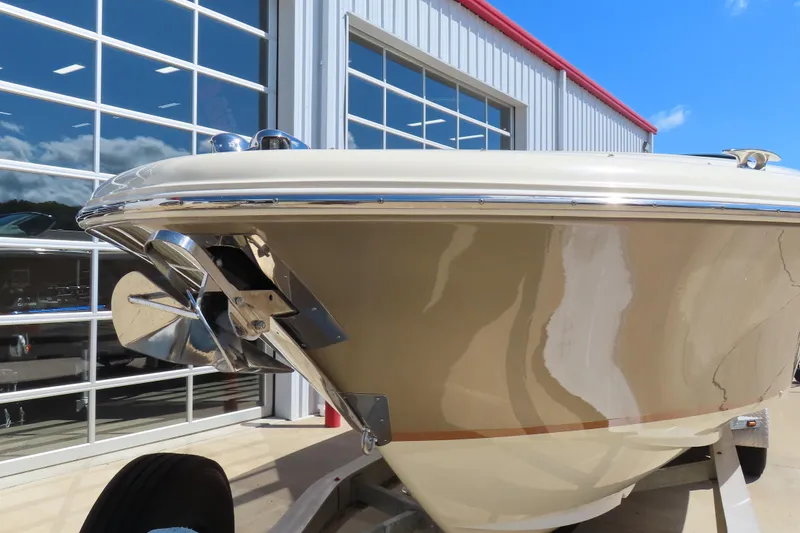 Slide: The Image of 2018 Chris Craft Launch 34 boat, beige hull, parked near a modern building. - 3