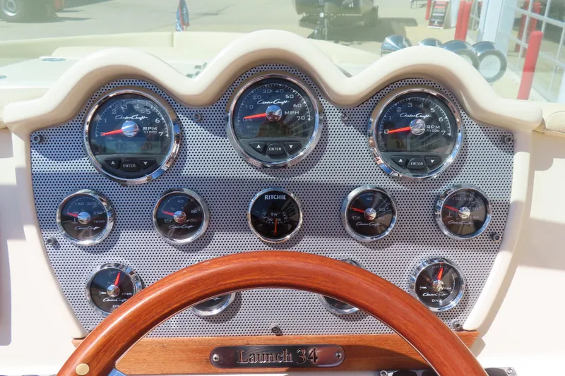 Slide: The Image of Dashboard of a 2018 Chris Craft Launch 34 boat with gauges and wooden steering wheel. - 31