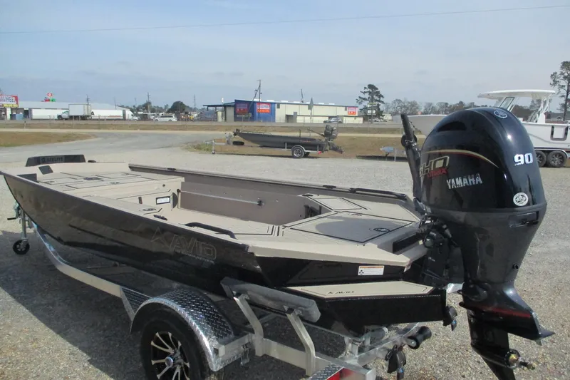 Slide: The Image of 2026 Avid 18 Commander boat with Yamaha 90 engine on trailer in outdoor setting. - 1