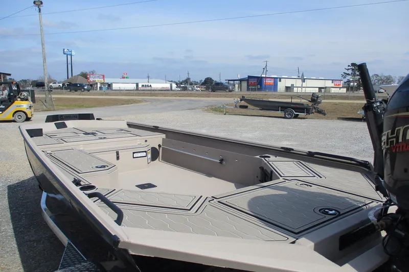 Slide: The Image of 2026 Avid 18 Commander boat with spacious deck, parked outdoors. - 5