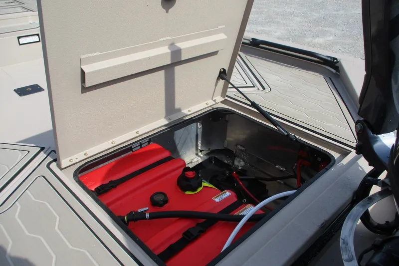 Slide: The Image of Open storage compartment in 2026 Avid 18 Commander boat showing red fuel tank. - 8