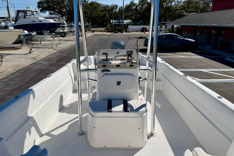 Slide: The Image of 2010 Carolina Skiff 192 DLV boat interior with console and seating, parked in a marina. - 17