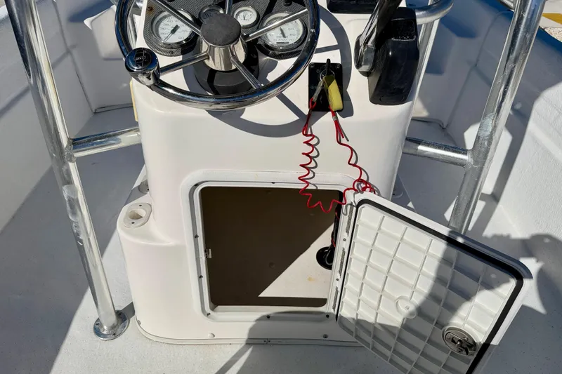 Slide: The Image of 2010 Carolina Skiff 192 DLV boat console with open storage compartment and steering wheel. - 24