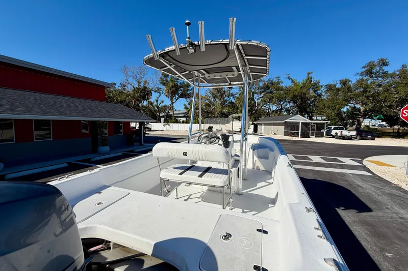 Slide: The Image of 2010 Carolina Skiff 192 DLV boat with T-top, parked outdoors under clear blue sky. - 25