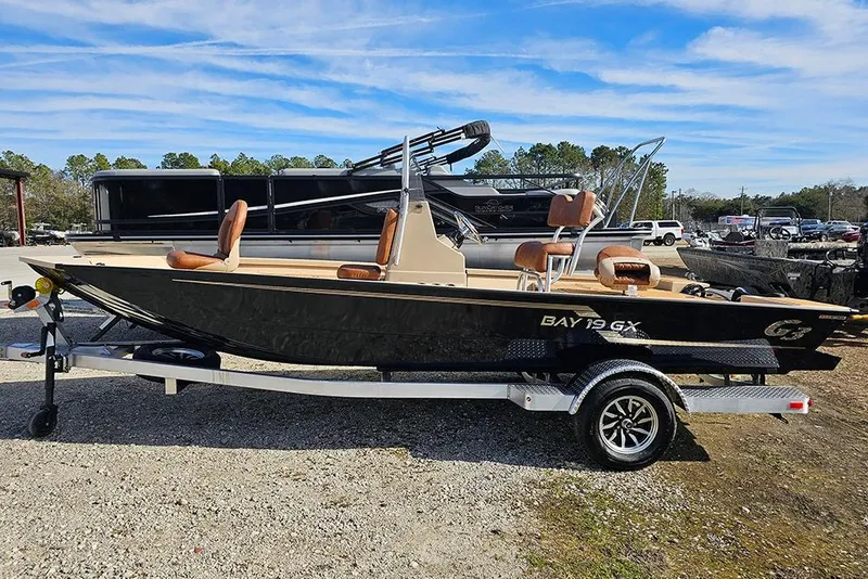 The Image of 2026 G3 Bay 19 GX boat on trailer, parked outdoors under blue sky. - 1