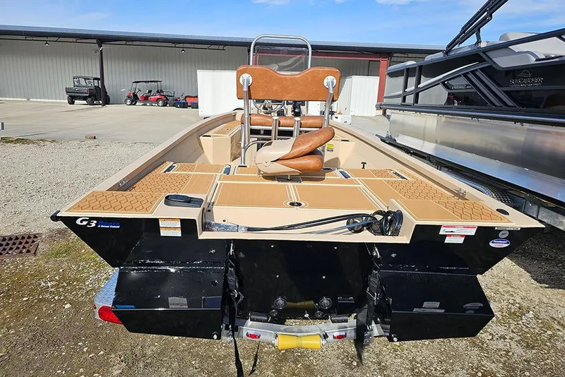 Slide: The Image of 2026 G3 Bay 19 GX boat, rear view, parked outdoors with tan seating and deck. - 7