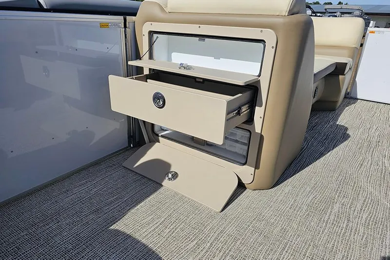 Slide: The Image of Open storage compartment on 2026 SunCatcher Select 22RF boat, featuring beige drawers and seating. - 14