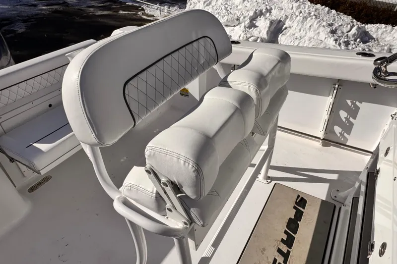 Slide: The Image of 2023 Sportsman Open 232 Center Console boat interior with white cushioned seating. - 10