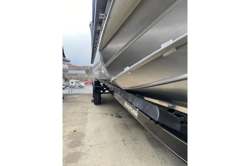 Slide: The Image of 2026 Manitou 23 Encore RF SHP pontoon boat on trailer, side view. - 11