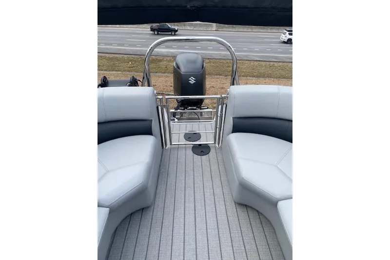 Slide: The Image of 2026 Manitou 23 Encore RF SHP pontoon boat interior with seating and Suzuki outboard motor. - 18