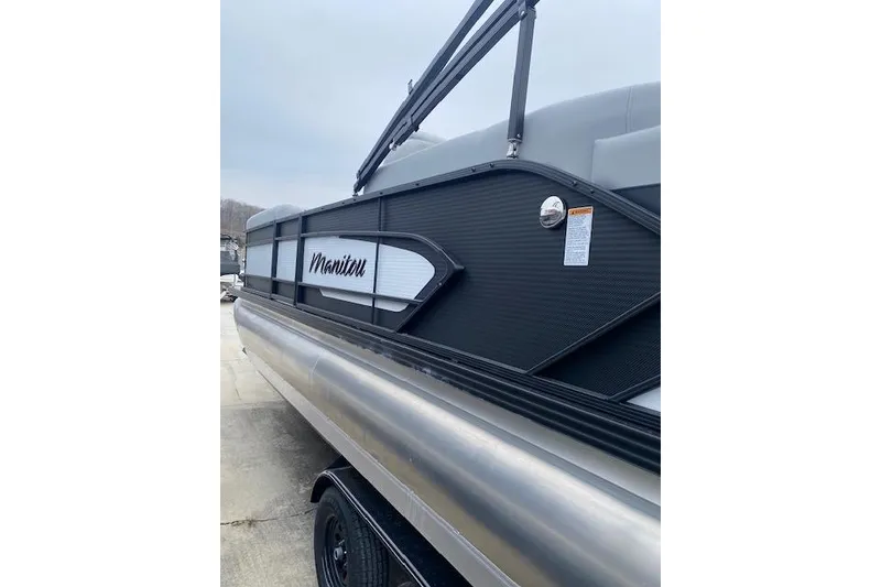 Slide: The Image of 2026 Manitou 23 Encore RF SHP pontoon boat, side view with sleek design. - 3