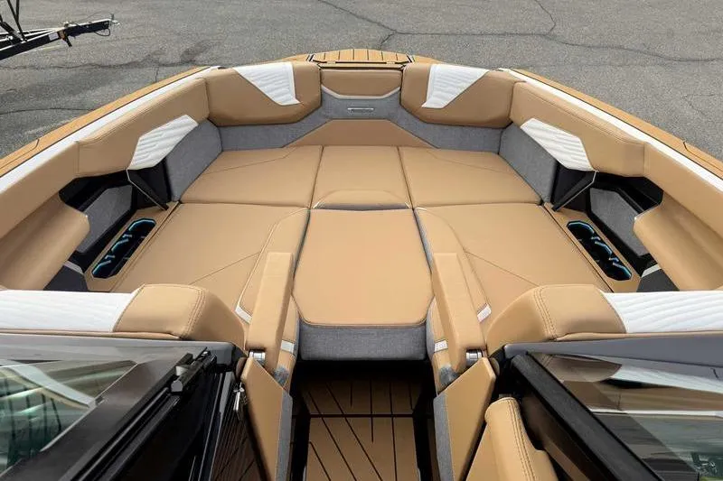 Slide: The Image of 2026 MasterCraft X24 boat interior with tan and gray seating, cup holders, and sleek design. - 11