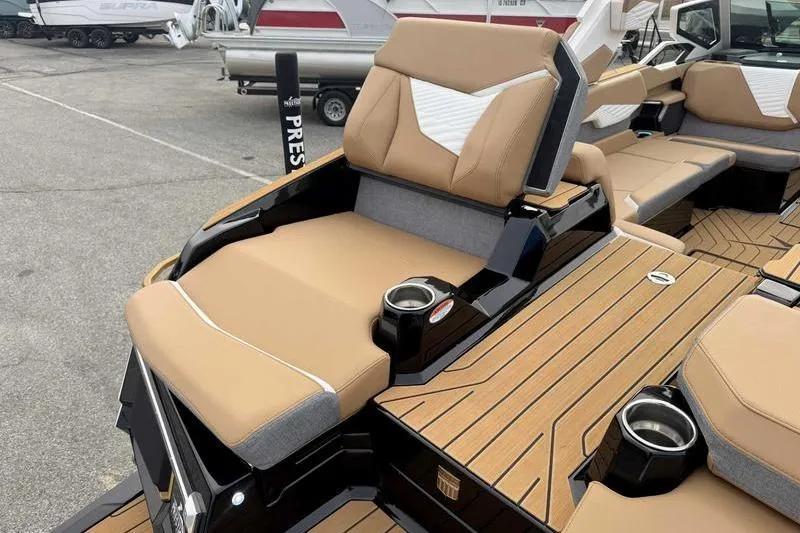 Slide: The Image of 2026 MasterCraft X24 boat interior with tan seating and cup holders. - 8