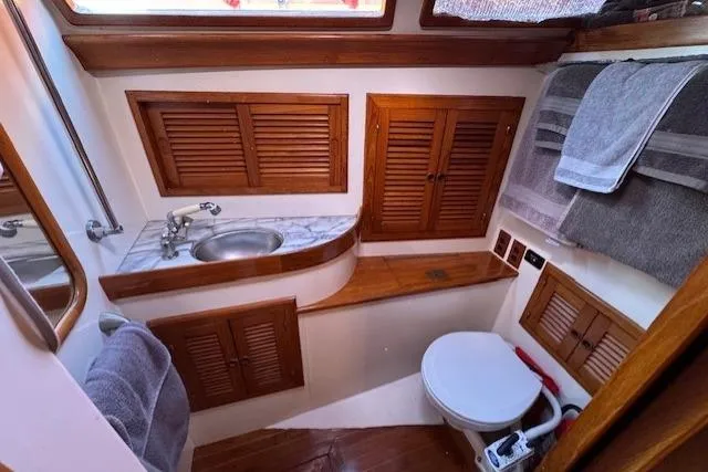 Slide: The Image of 1986 Fairweather Mariner 39 yacht bathroom with wooden cabinets and compact design. - 10