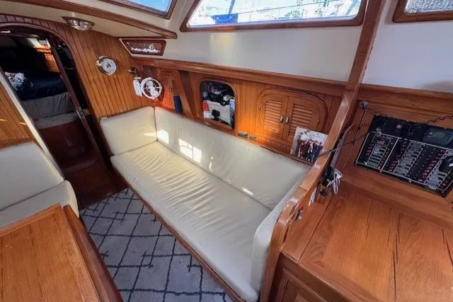Slide: The Image of Interior of 1986 Fairweather Mariner 39 sailboat with wooden paneling and cozy seating area. - 13