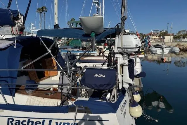 Slide: The Image of 1986 Fairweather Mariner 39 sailboat docked in marina, featuring blue canopy and equipment. - 42