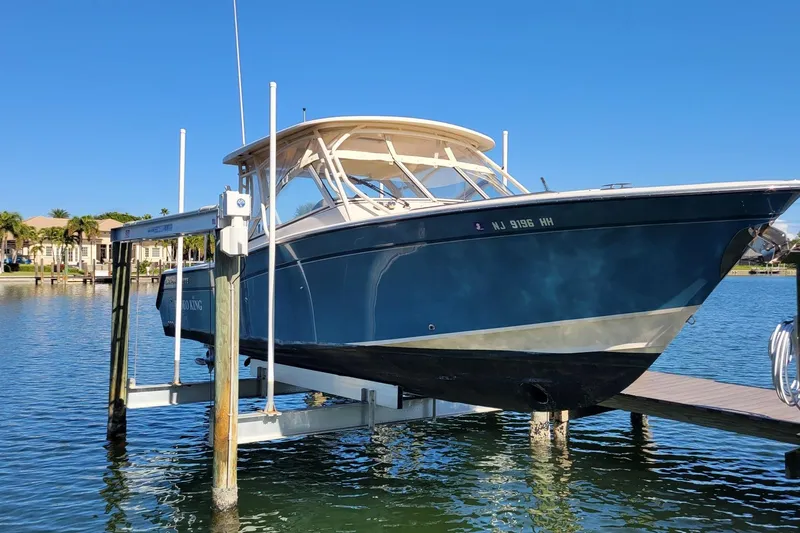 The Image of 2019 Grady-White Freedom 307 boat on lift, docked by waterfront homes. - 0