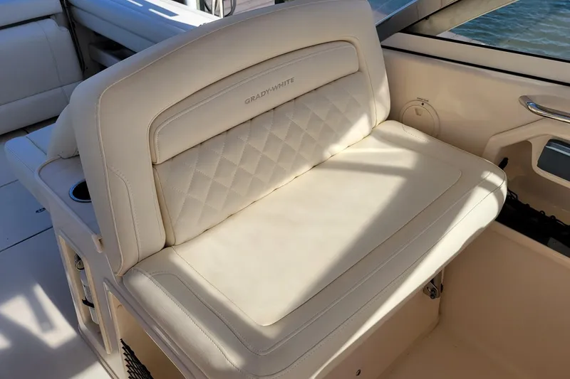 Slide: The Image of 2019 Grady-White Freedom 307 boat seat with beige upholstery and cup holder. - 10