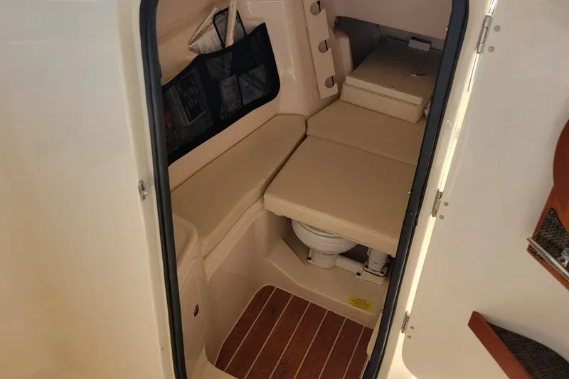 Slide: The Image of 2019 Grady-White Freedom 307 boat interior cabin with seating and toilet. - 11