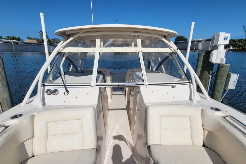 Slide: The Image of 2019 Grady-White Freedom 307 boat interior with seating, docked by calm water. - 18