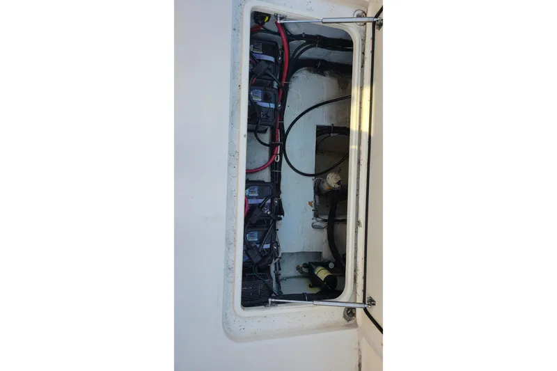 Slide: The Image of 2019 Grady-White Freedom 307 boat battery compartment with wiring and components. - 19