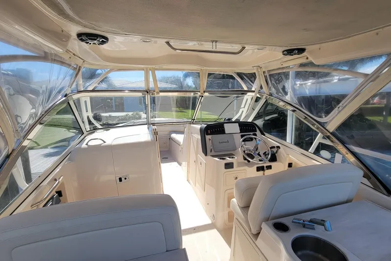 Slide: The Image of 2019 Grady-White Freedom 307 boat interior with helm, seating, and clear canopy. - 8