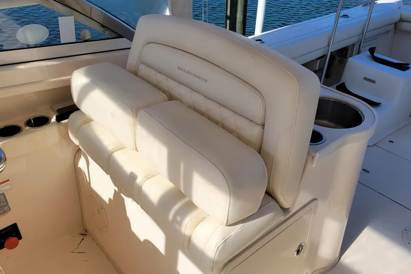 Slide: The Image of 2019 Grady-White Freedom 307 boat interior with cushioned seating and cup holders. - 9
