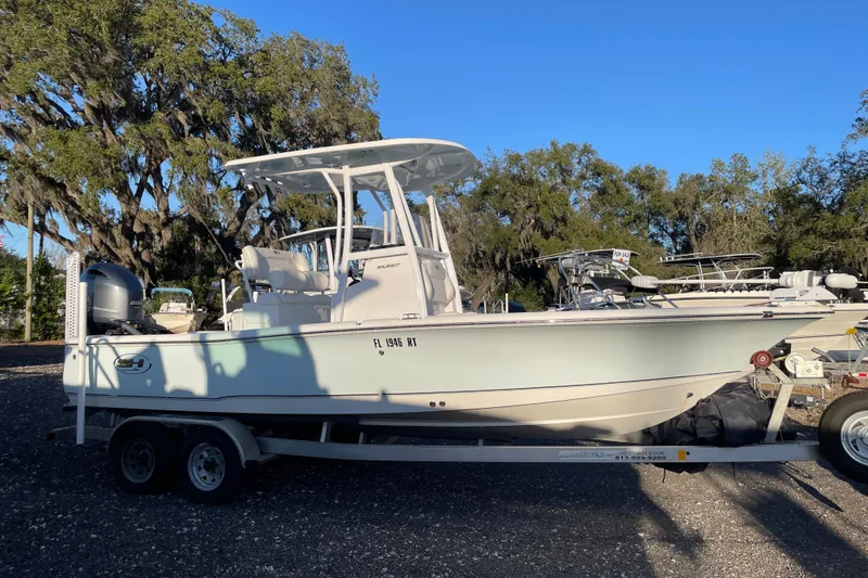 The Image of 2019 Sea Hunt BX 22 BR boat on trailer, parked outdoors under clear blue sky. - 0