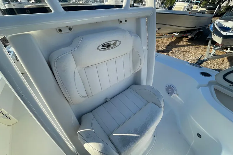 Slide: The Image of 2019 Sea Hunt BX 22 BR boat seat with logo, white upholstery, and surrounding deck area. - 11