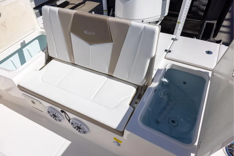 Slide: The Image of 2023 Robalo 246 Cayman boat seating and storage area with integrated speakers. - 10
