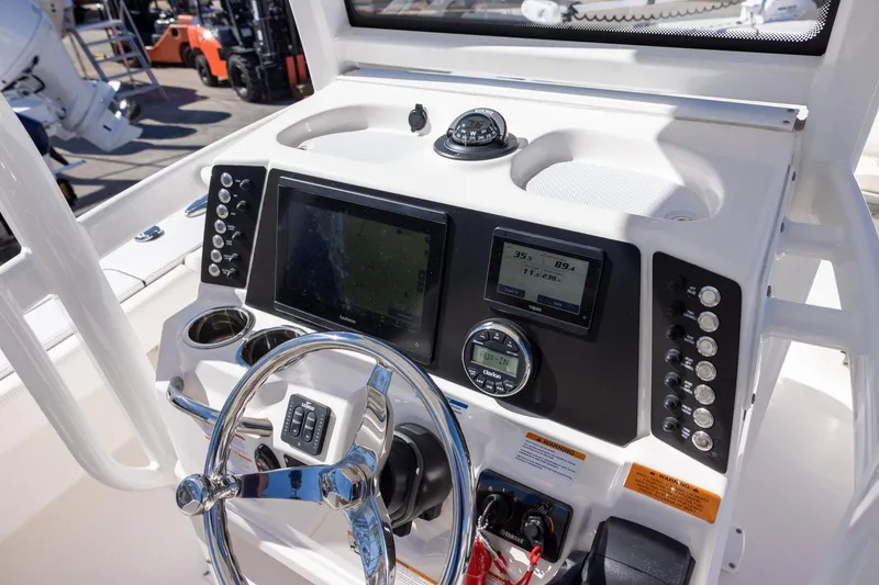 Slide: The Image of 2023 Robalo 246 Cayman boat dashboard with steering wheel and navigation controls. - 14