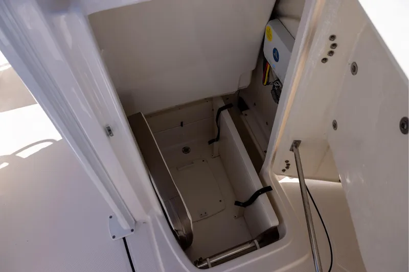 Slide: The Image of 2023 Robalo 246 Cayman boat storage compartment with secure straps and wiring. - 17