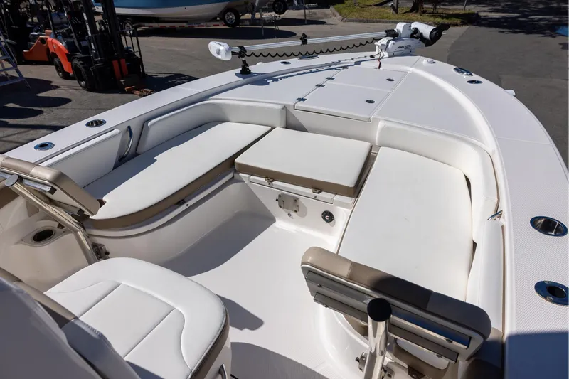 Slide: The Image of 2023 Robalo 246 Cayman boat interior with cushioned seating and fishing rod holders. - 18