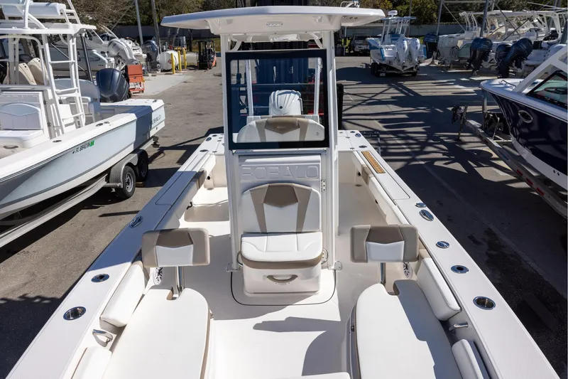 Slide: The Image of 2023 Robalo 246 Cayman boat interior, featuring seating and console, docked among other boats. - 20